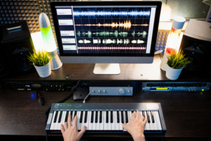 Musicians hands on keyboard with computer