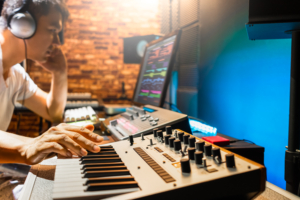 Musician in sound studio using synthesizer